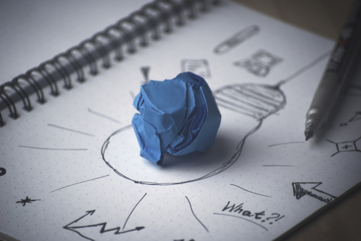 Lightbulb drawing on white paper with blue paper ball